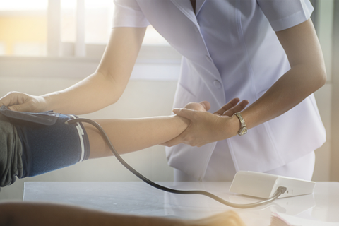 Sykepleier som sjekker blodtrykk på pasient
